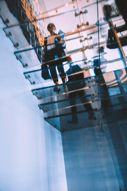 Business people walking on modern glass staircases