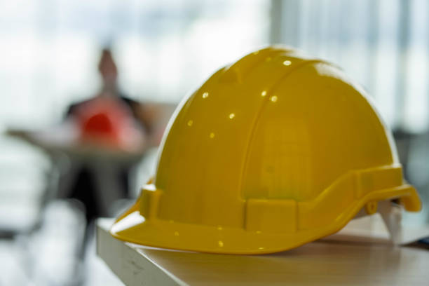 istock selected focus of safety red hard hat in construction site with blurred background of caucasian engineer .  social distancing new normal concept. 1277586898