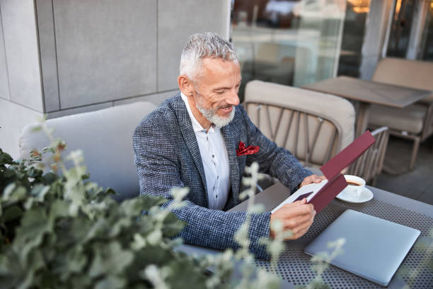 istock Smiley senior man looking at card inside a box 1277587832