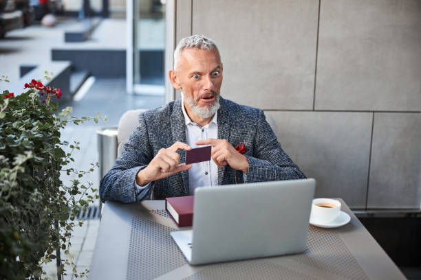 istock Thrilled senior citizen with a plastic card making a video-call 1277587869