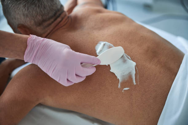 istock Professional spa staff putting cream on an aged man back 1277587894