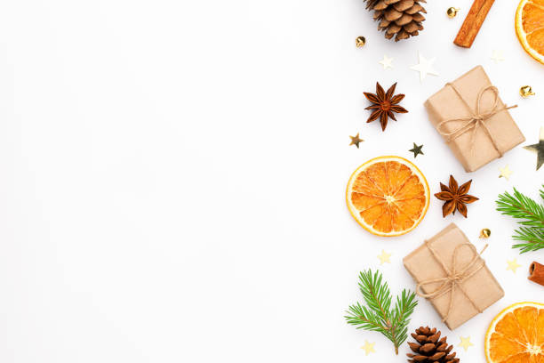 istock Christmas frame. Gift with fir tree, dry orange, cinnamon sticks, pine cones, star anise, baubles, confetti on white background. 1277589672