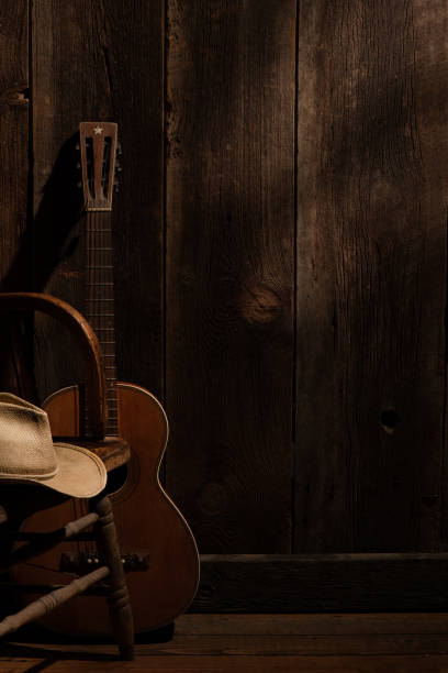 istock Guitar and cowboy hat with barnwood background with subdued lighting 1277589867