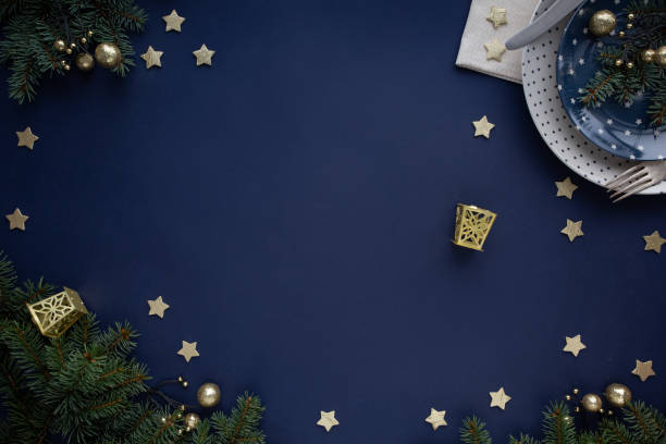 Christmas decorated table with plate, fir branches and golden decorations