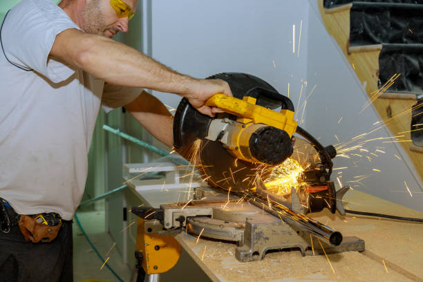 Worker man cutting a metal pipe with a circular saw with splashes of sparks. Worker a man cutting a metal pipe with a circular saw with splashes of sparks miter saw stock pictures, royalty-free photos & images