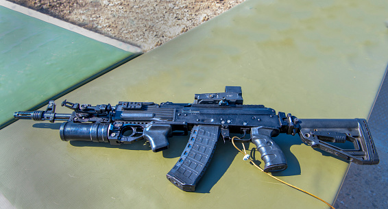 Caucasian female and male military team, having an outdoor military training, practising a fast assembly of weapons