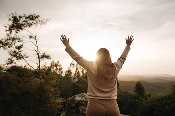 istock Young woman with arms raised at sunset 1277593881