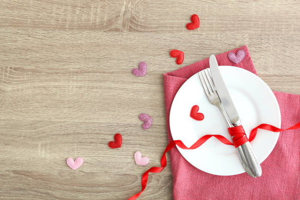istock Festive table setting for Valentine's Day with cutlery, gift boxes and hearts on the table. Space for text. View from above. 1277595593