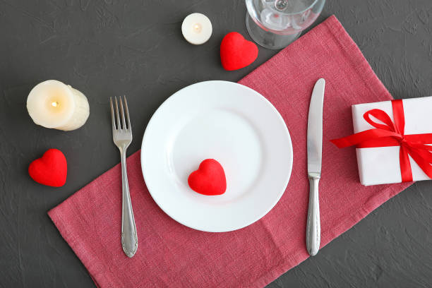 istock Festive table setting for Valentine's Day with cutlery, gift boxes and hearts on the table. Space for text. View from above. 1277596025