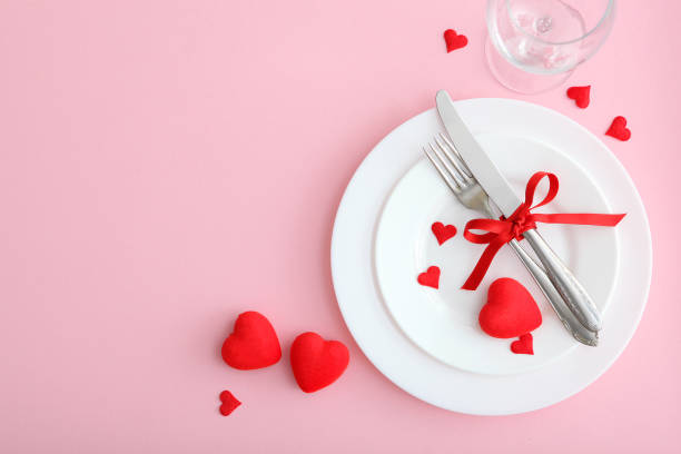 istock Festive table setting for Valentine's Day with cutlery, gift boxes and hearts on the table. Space for text. View from above. 1277596139