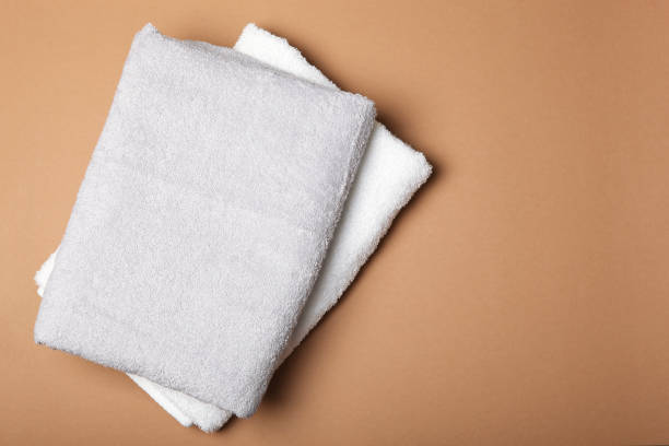 istock Fresh towels on a colored background with place for text top view. 1277599182