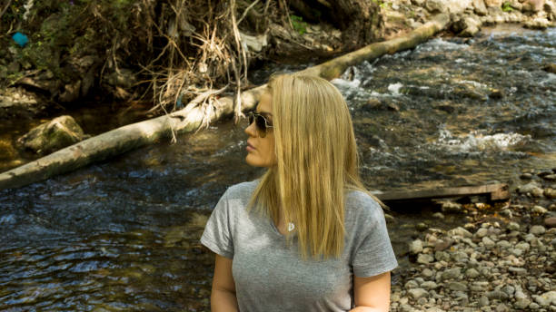 istock Young woman near the river in summer 1277603270