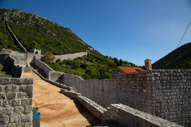istock Stone wall towards mountain with church inside red roof 1277605483