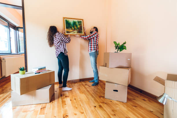 istock Excited couple hanging picture on wall 1277605602