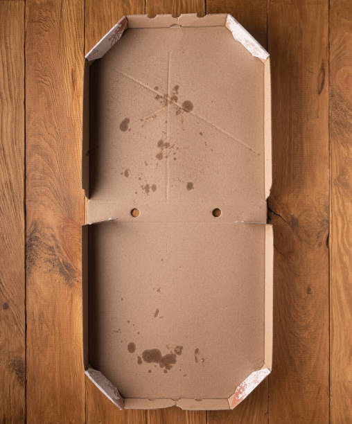 istock Opened dirty pizza box on wooden background 1277607983