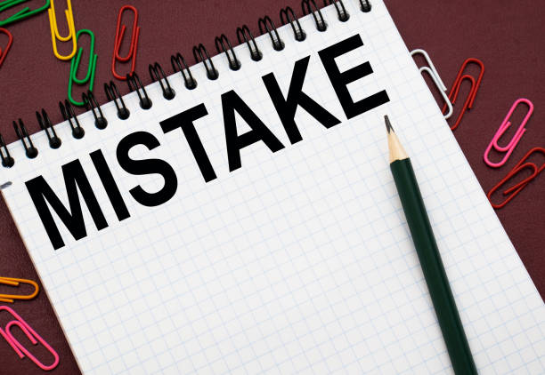 istock Design concept - Top view of white spiral notebook and pencil with text MISTAKE isolated on red background for mockup 1277608820