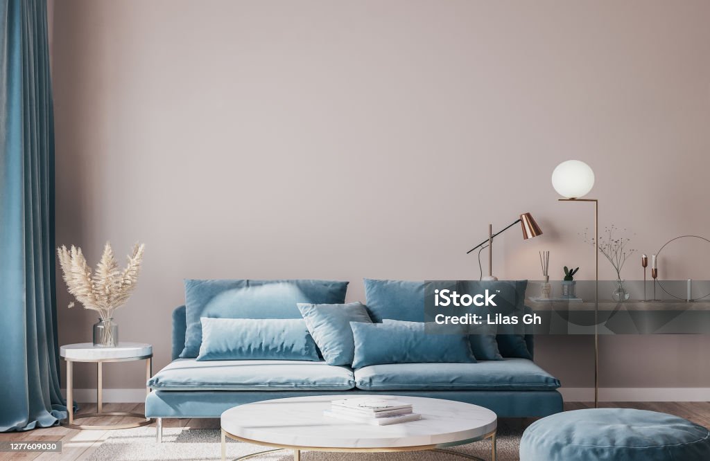 stylish modern interior of living room with trending home accessories, marble coffee table, dried flowers, and blue sofa. Front View Stock Photo