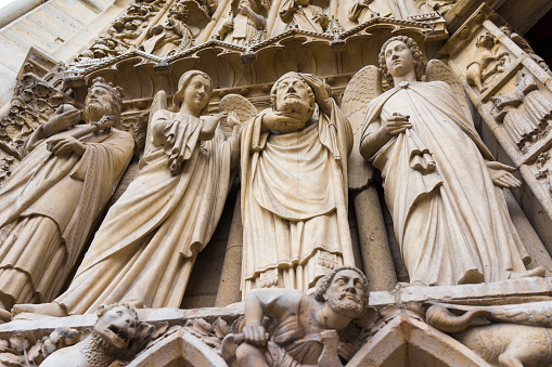 Sculptures of angels and saints on the main façade of the Notre Dame Cathedral in Paris, one of the crown jewels of European Gothic art.