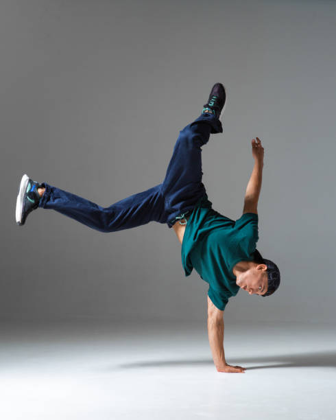 istock Cool b-boy dancing on one hand in studio isolated on gray background. Breakdance poster 1277610742