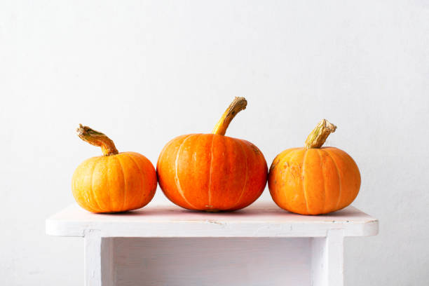 istock Orange pumpkins on the white wooden table 1277610769