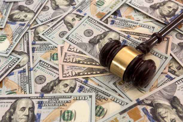 istock Many hundred dollar bills with judge gavel 1277610941