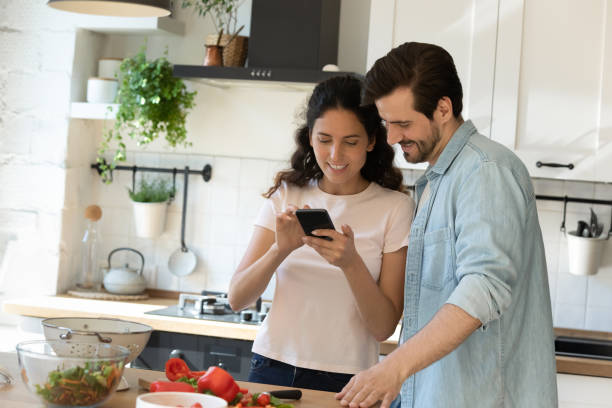 istock Happy couple tenants cooking at home using cellphone 1277611174