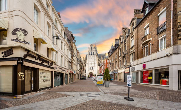 Shopping precinct leading to the Basilica of Saint Quentin at sunset (church)  in Saint Quentin, Aisne, France stock photo
