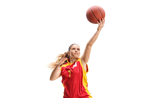 Female basketball player doing layup isolated on white background