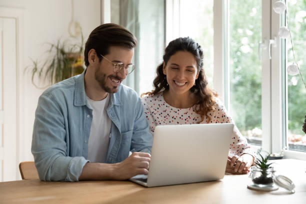 istock Smiling couple using laptop at home together 1277613379