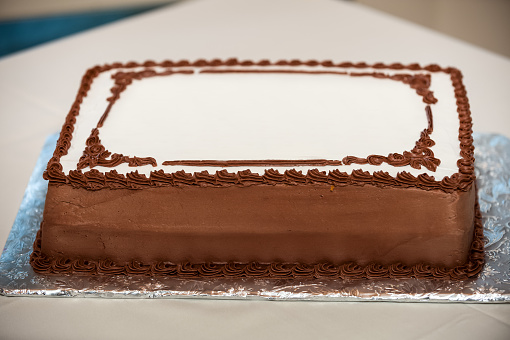 Blank Sheet Cake with Chocolate Trim Icing on aluminum foil.