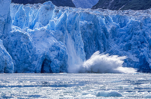 Tidewater glacier calving into Alaskan Bay, causing a huge disruption on the calm water surface.

Taken in Southeast Alaska.