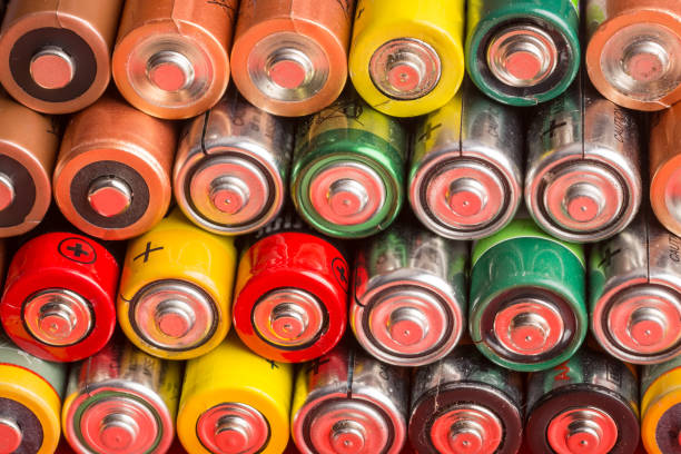 Stack of used batteries on a red background