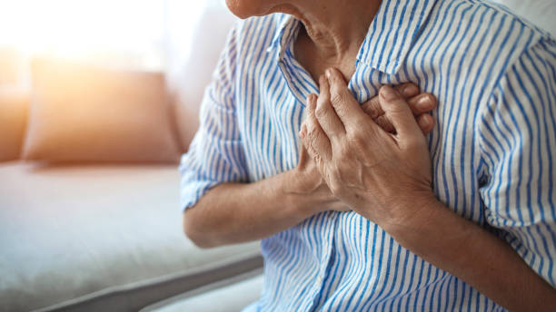 upset stressed mature middle aged woman feeling pain ache touching chest having heart attack - peito imagens e fotografias de stock