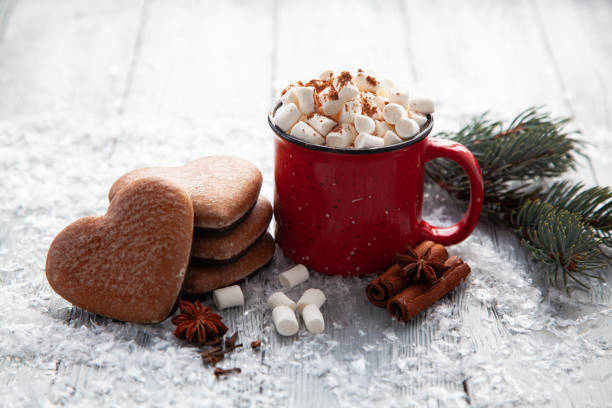 xícara de cacau quente com marshmallows e pão de gengibre de natal na forma de um coração em um fundo de madeira nevado. - holiday cookies - fotografias e filmes do acervo