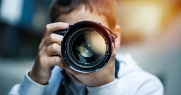 jonge mens die camera van dslr gebruikt - fotograaf stockfoto's en -beelden