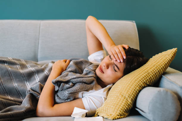 istock Tired young female touching forehead having headache migraine, lying on a sofa 1277621644