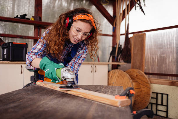 istock Young female carpenter grinding plank. 1277622962