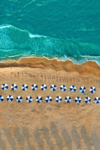 istock Empty beach, drone view. Umbrellas, blue water and golden sand 1277626130