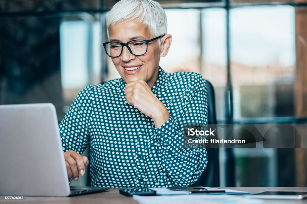 Business woman working Senior businesswoman working at the office, using laptop and documents Senior Adult Stock Photo