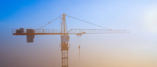 istock Construction cranes at dawn in the morning mist. 1277630036