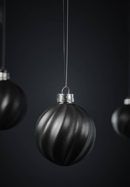 istock Three twisted striped black Christmas balls against dark gray background. 1277635280