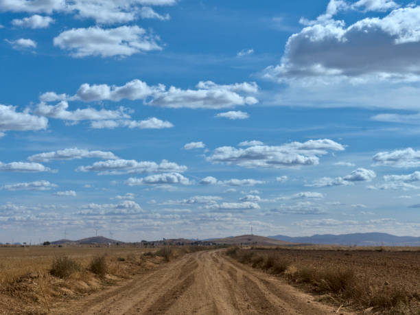 istock Country side view with empty road, blue sky and white cotton clouds 1277636727