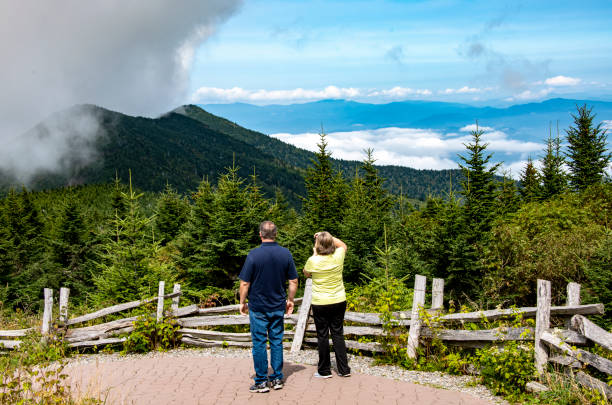 tourists Mount Mitchell A couple is photographing mountain scenery on Mount Mitchell, North Carolina. A female is holding up a camera to take a photo. mt mitchell stock pictures, royalty-free photos & images