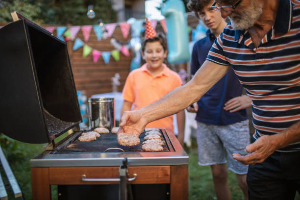 istock Grandfather grilling meat for a barbecue party 1277638088