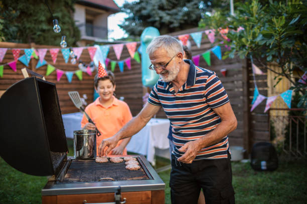 istock Grandfather grilling meat for a barbecue party 1277638663
