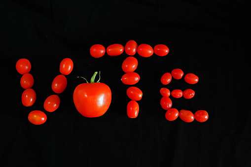 Cherry  tomatoes and one vine tomato spelling out the word 