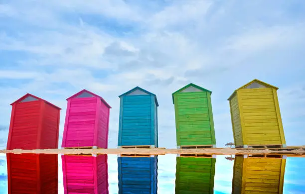 Photo of Colorful beach huts with cloudy sky. Copy space