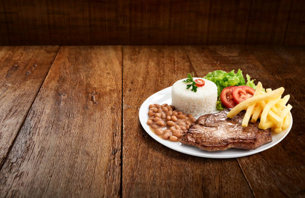 Rump meat steak executive dish with rice, beans, salad, fries Rump meat steak executive dish with rice, beans, salad, fries, on wooden background beans and rice stock pictures, royalty-free photos & images
