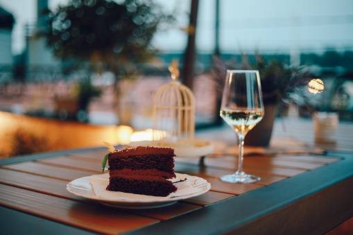 Delicious chocolate cake and a glass of wine on the restaurant table.