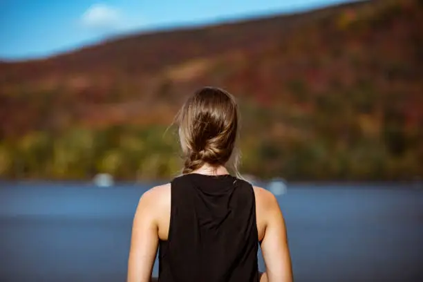 Female hiker in the mountains on a fall day with vibrant fall trees.